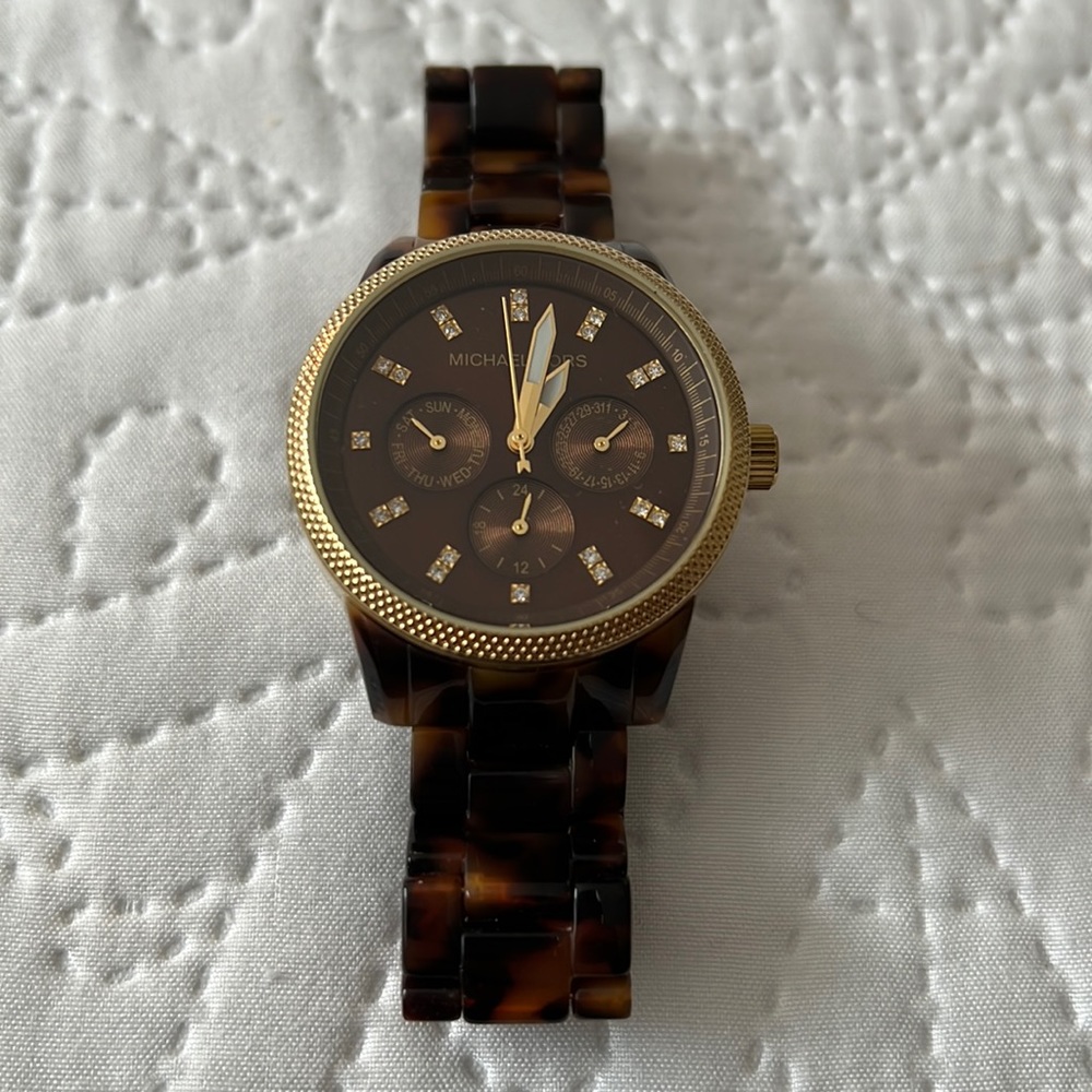 Beautiful brown tortious Michal Kors watch with crystals on face and gold trim.